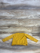 Back view of H and M yellow fine-knit toddler jumper sweater showing long sleeves and ribbed hem on wood background