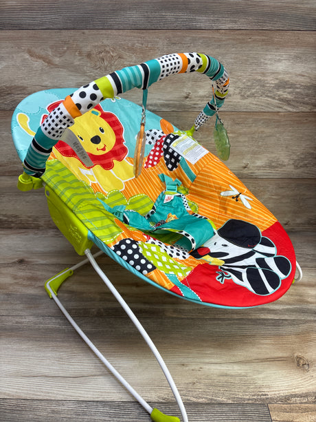 Angled view of Bright Starts Roaming Safari vibrating baby bouncer showcasing colorful safari print and toy bar on wood floor