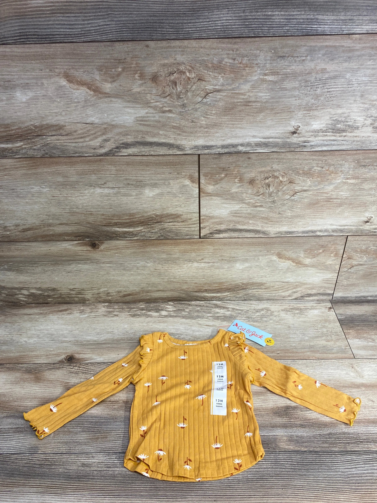 Yellow long sleeve baby shirt with white daisy print and ruffle details, size 12 months