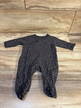 Front view of a Side Snap Sleeper with long sleeves, footed legs, and cream polka dots on a wood floor