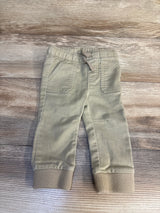 Beige toddler jogger pants with elastic waistband and cuffs on wood background