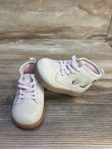 Light pink toddler shoes with heart cutouts and laces on wooden surface