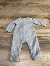 Top view of Carters gray quilted coverall in size 6 months showing long sleeves and ribbed cuffs on a wood surface