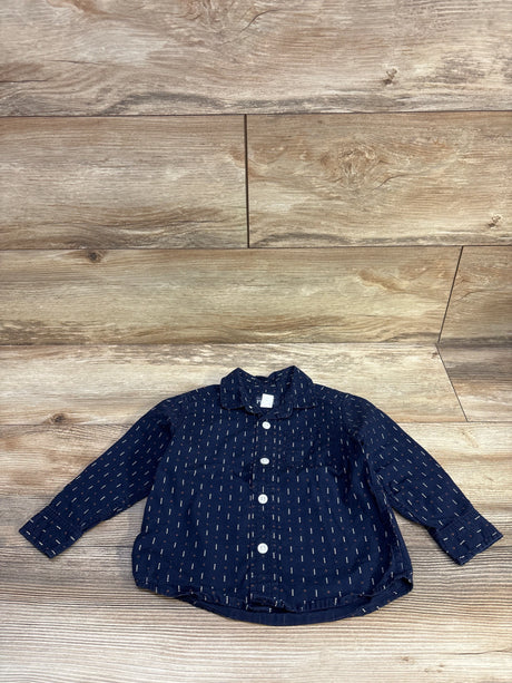 Flat lay of Children’s Place navy button-up toddler shirt showing white buttons and orange dash print on wood background