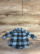 Flat lay of newborn Old Navy blue plaid button-up shirt showing front buttons and chest pocket on wood floor background