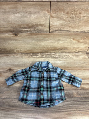 Flat lay of newborn Old Navy blue plaid button-up shirt showing front buttons and chest pocket on wood floor background