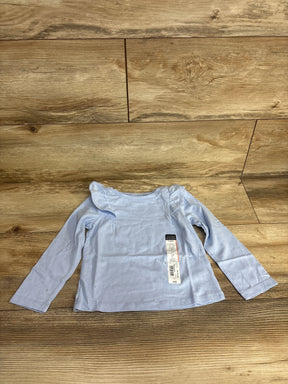 Light blue long sleeve toddler shirt with ruffle shoulders on wood background, resale kids clothing