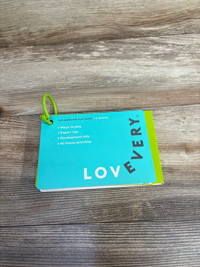 Lovevery play guide booklet for 7-8 months on wood table, green binder ring