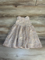 Pink lace baby girl dress with floral pattern and buttons, displayed on wood background