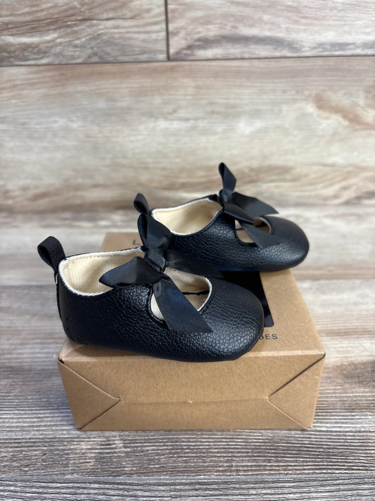 Black baby Mary Jane shoes with bows, soft sole, on box