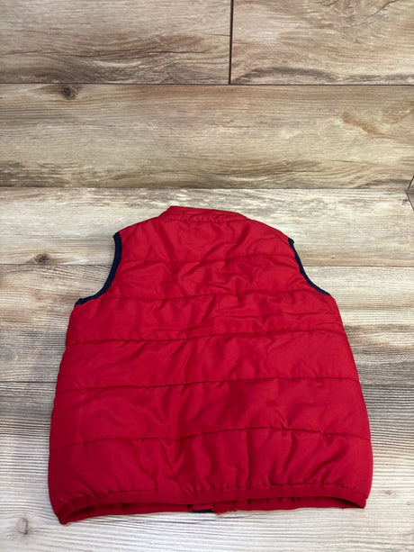 Back view of a red Tommy Hilfiger puffer vest in size 24 months showcasing quilted panels and dark trim on a wood floor