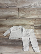 Children's light beige and white striped long sleeve top with buttons and pants set on wood background
