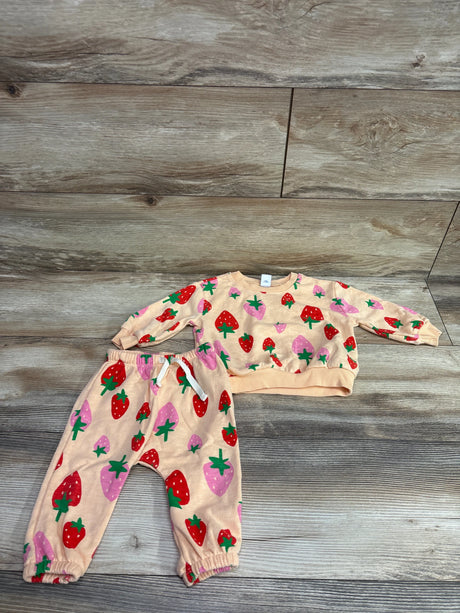 Flat lay of Old Navy two piece pullover sweatshirt and joggers set in orange with strawberry print on a wood look background