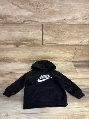 Black kids Nike hoodie with white logo, long sleeves, front pouch pocket on wood background