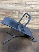 Three-quarter view of Baby Delight Alpine Deluxe Bouncer in quilted indigo showcasing reclined seat with toy bar on wood plank floor