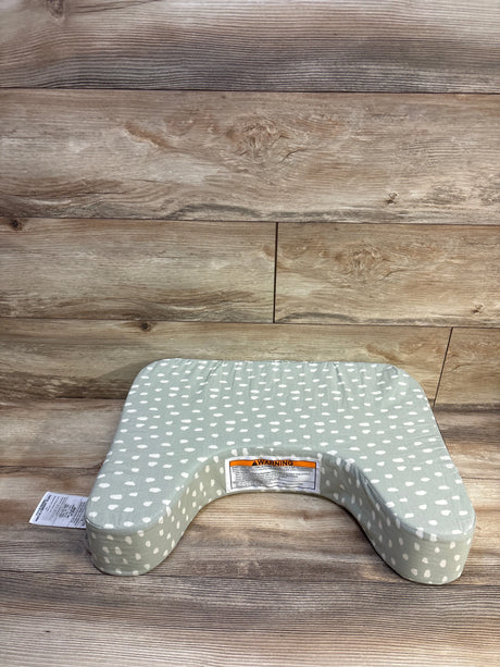 Front view of Leachco The Natural Nursing Pillow in sage green with white dots on a wood-look floor