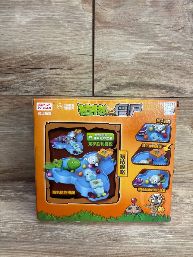 Plants vs Zombies themed children's tabletop game with colorful balls, blue play area, and character figures on wooden floor