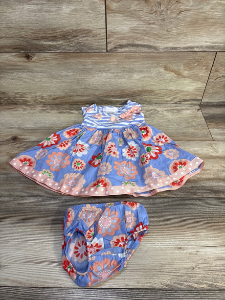 Flat-lay of Bonnie Baby blue 2pc floral sleeveless dress and bloomers showcasing striped bodice, bow and polka-dot hem on wood background