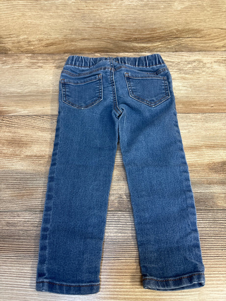 Back view of children's blue denim jeans with elastic waistband on wood background
