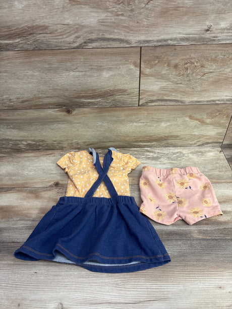 Top down view of Pekkle three piece floral skirtall set with yellow floral top, navy skirtall, and pink floral shorts on wood flooring