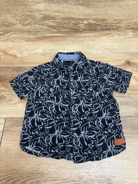 Front view of 7 For All Mankind navy button-up shirt with floral print, chest pockets, and front buttons on wood