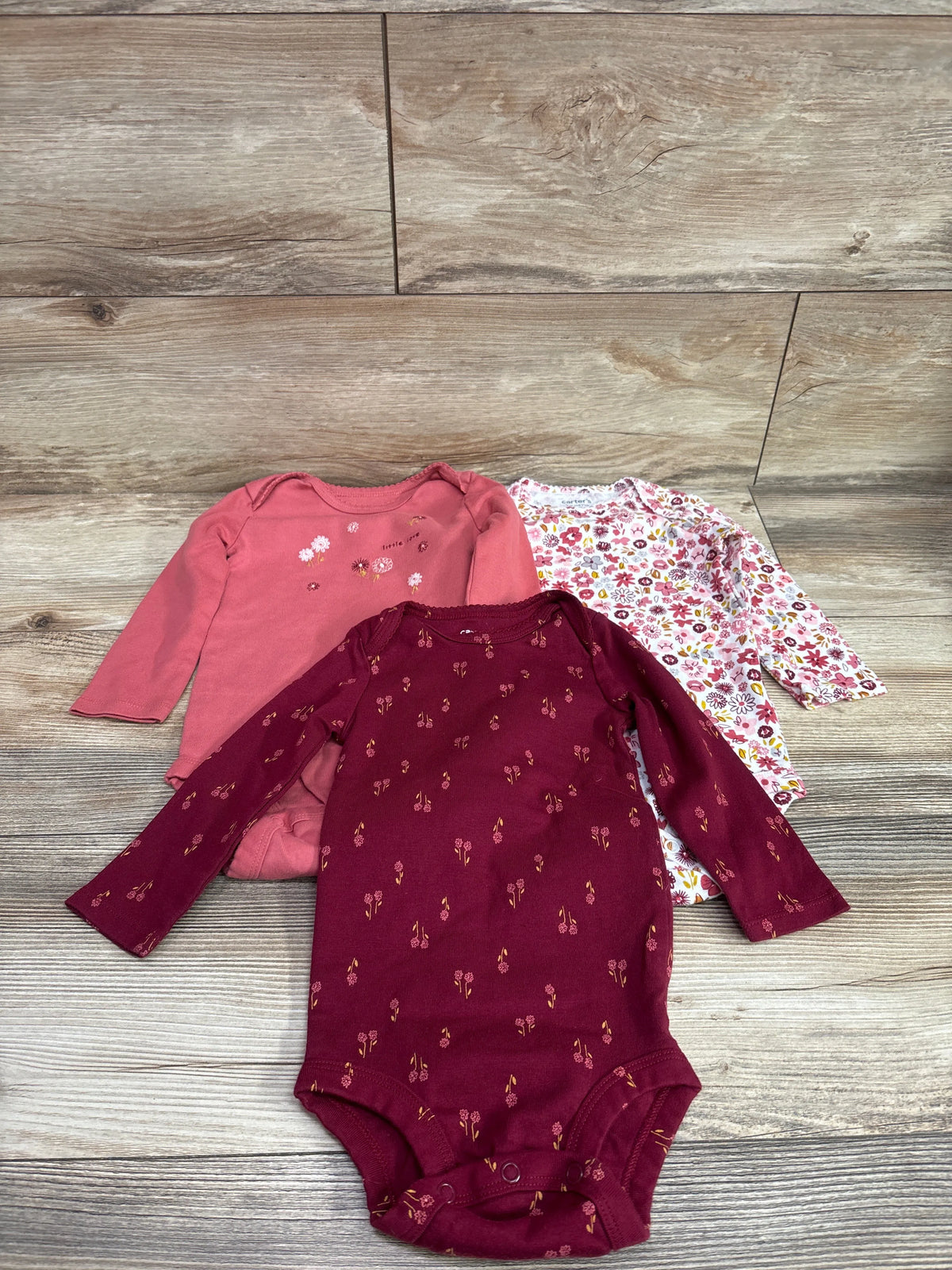 Set of three long sleeve baby bodysuits in red, pink, and floral patterns from Me n Mommy To Be.