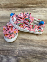 Angled side view of Limited Too pink slip-on sneakers (size 8C) showcasing ruffle bow and rainbow print with wood background