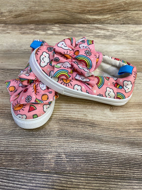 Angled side view of Limited Too pink slip-on sneakers (size 8C) showcasing ruffle bow and rainbow print with wood background