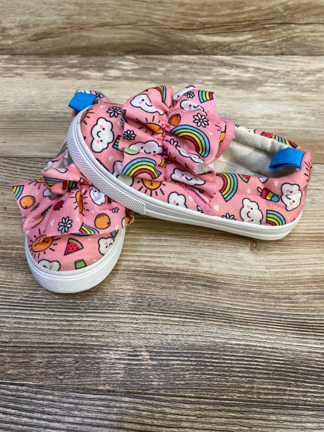 Angled side view of Limited Too pink slip-on sneakers (size 8C) showcasing ruffle bow and rainbow print with wood background