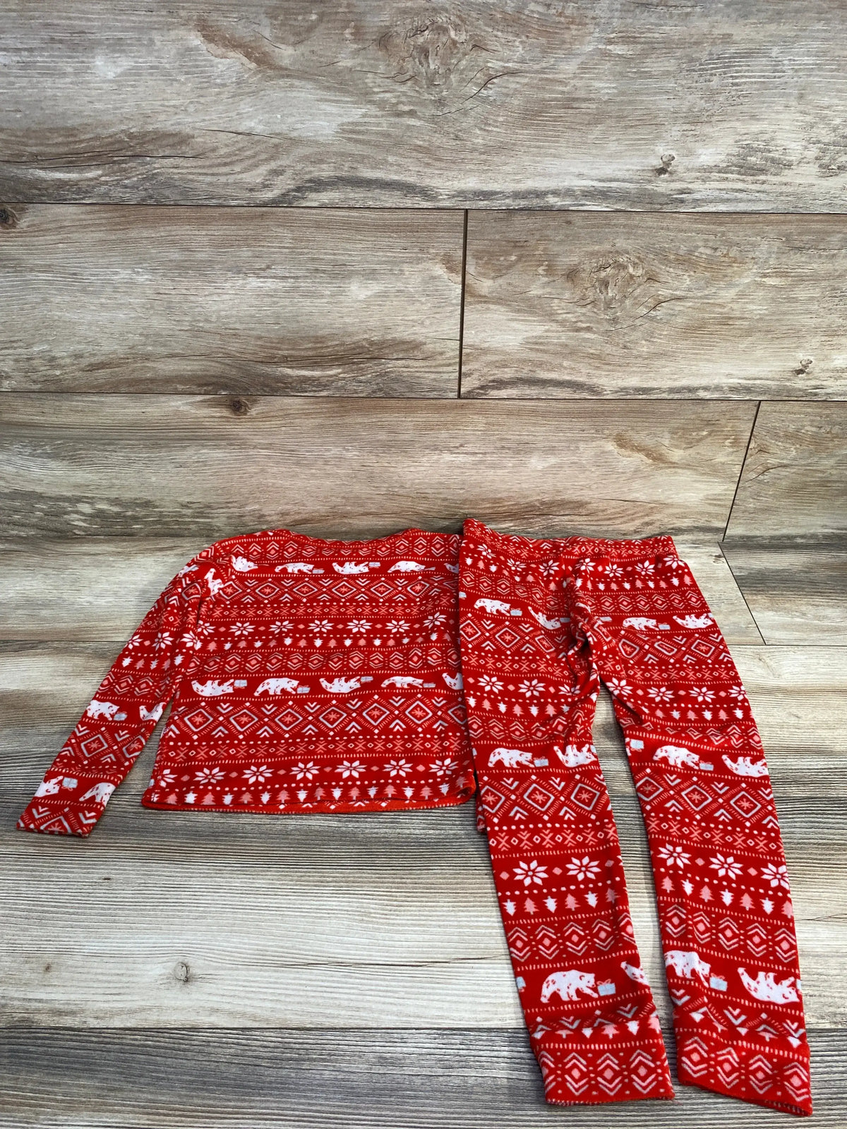 Red kids holiday pajama set with polar bears and snowflakes on wood floor