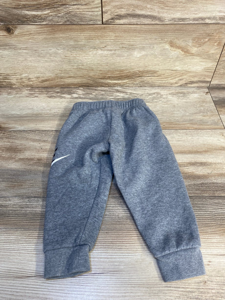 Gray kids sweatpants with elastic waistband and cuffed ankles on wooden floor