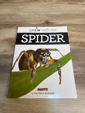 Children's book 'Grow With Me Spider' with close-up spider photo on wooden table