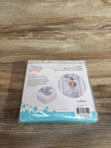 Top-down view of Disney Dumbo fitted crib sheet in packaging showcasing Dumbo photo-op print and brand on wood floor