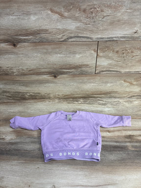 Lavender toddler sweatshirt with long sleeves and BONDS logo on hem on wooden floor