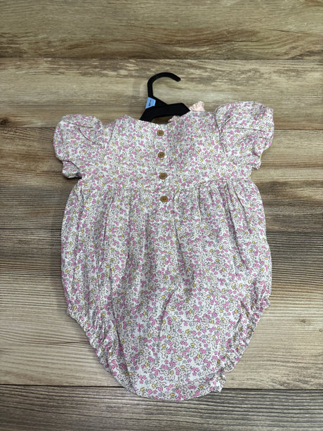 White Child Of Mine floral bubble romper with pink and yellow flowers on a wooden background