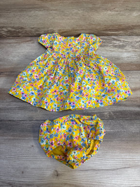Yellow floral baby dress with matching bloomers on wood background