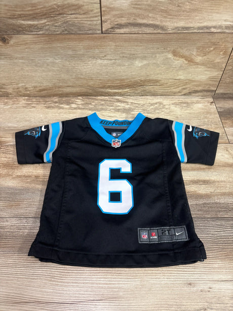 Front view of a black Nike Carolina Panthers Baker Mayfield number 6 jersey showcasing blue and white trim with a wood floor background