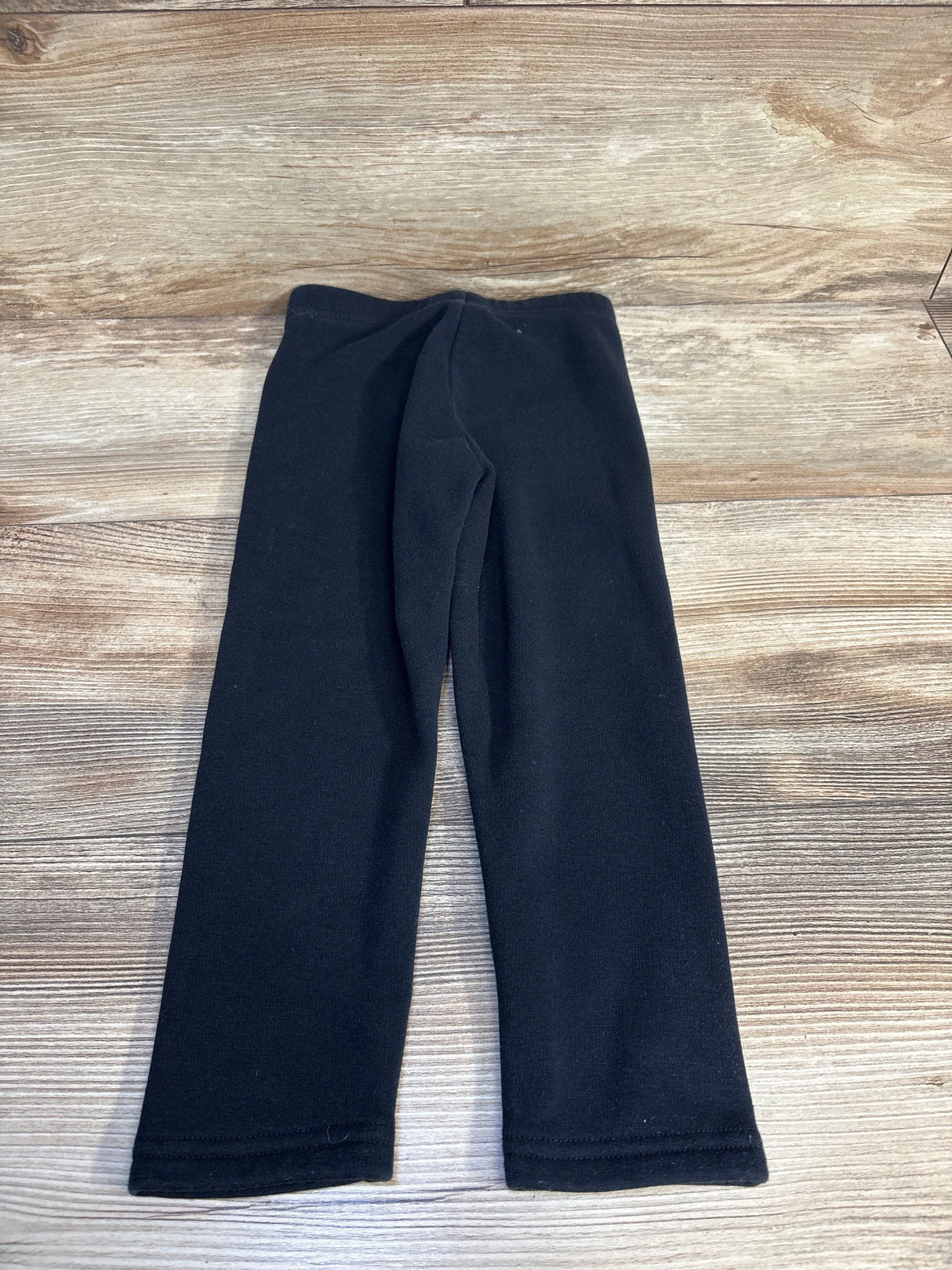 Black toddler leggings on wooden floor, kids clothing resale