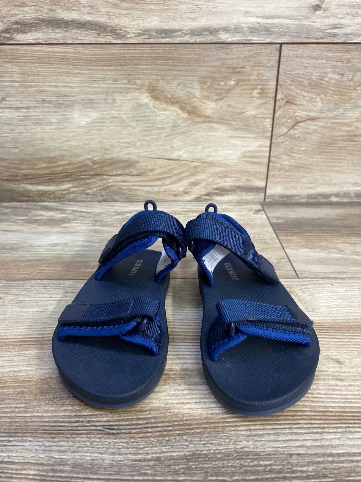 Front view of Old Navy navy double-strap toddler sandals size 8C showing adjustable Velcro straps on wood floor