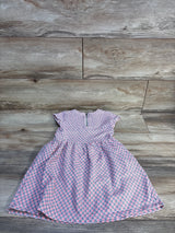 Flat lay of Carter's pink toddler dress size 4T showcasing small geometric floral pattern, cap sleeves, gathered skirt and back zipper on wood floor background