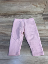 Flat lay of Carter's pink ribbed baby leggings, size 24 months, showing ribbed texture and elastic waistband on wood floor background