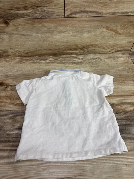 Back view of a white Tommy Bahama polo shirt for toddlers, size 24m, on a wood background.