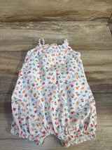 Flat lay of white shortie romper size 18 months showcasing multicolored floral print and elastic ruffled leg openings on wood background