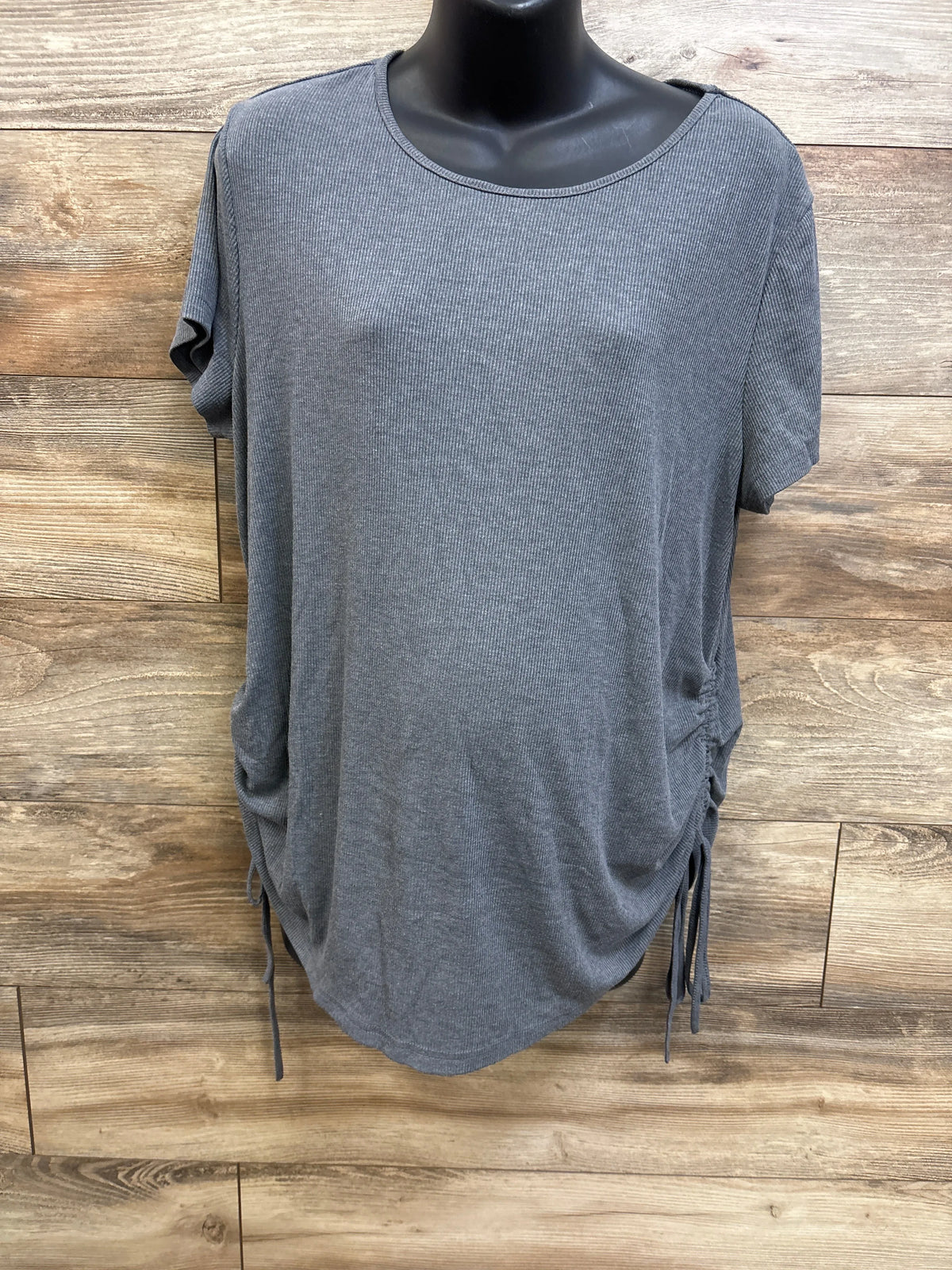 Front view of gray ribbed maternity shirt showcasing ruched side drawstrings on a black mannequin