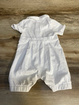 White baby romper with short sleeves and back snaps on wood surface