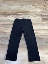 Flat-lay of black Amazon Essentials toddler leggings, front view showing elastic waistband and full-length legs on wood floor