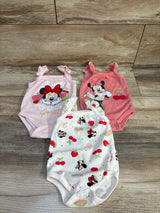 Top-down view of three Disney Baby Minnie Mouse infant bodysuits showcasing front character prints and ruffle shoulder straps on light wood background