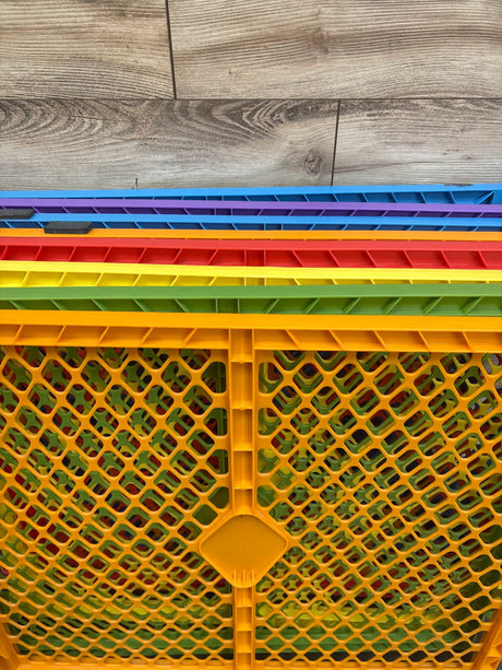 Close-up of Toddleroo by North States Colorplay 8-panel gate showing multicolored lattice panels on a wood-look floor