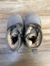 Top view of Ugg Neumel II toddler boots in grey, size 8C, showing plush faux-shearling lining and lace-up front on wood floor