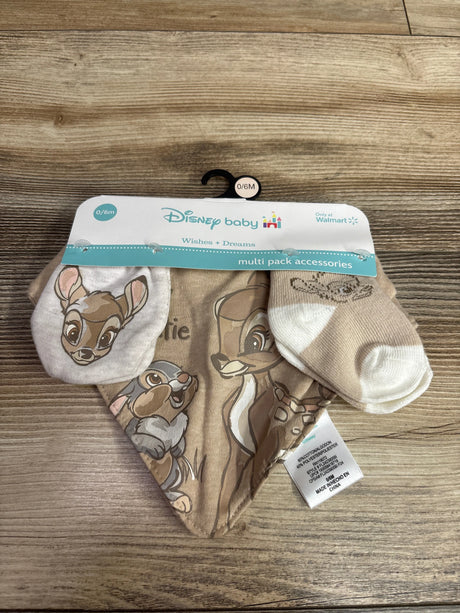 Front view of Disney Baby Bambi bib, mittens, and socks set with character prints on wood background